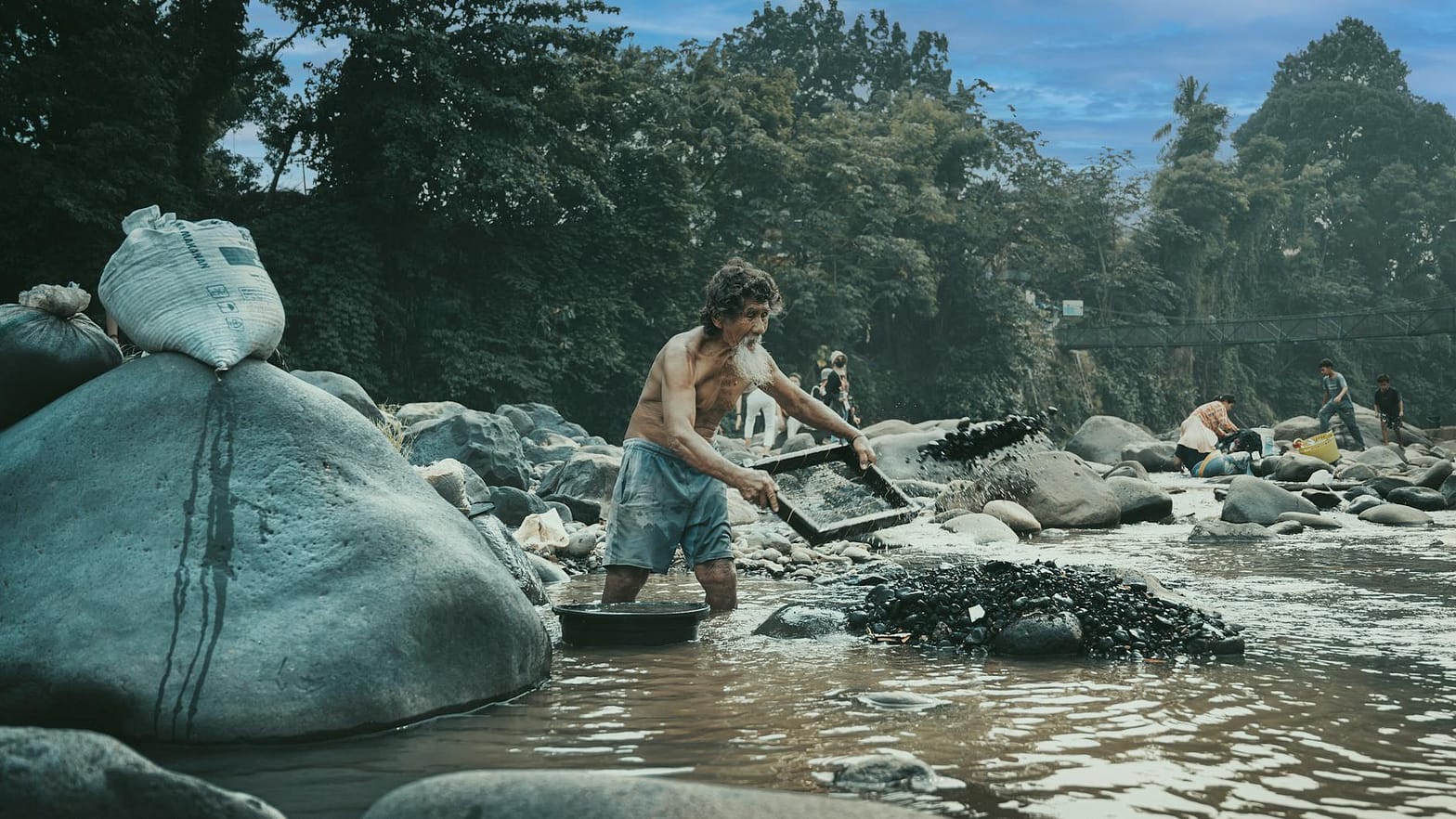man panning for gold in indonesian river
